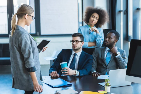 Multikulti-Geschäftsleute schauen Geschäftsfrau mit Tablet im Büro an — Stockfoto