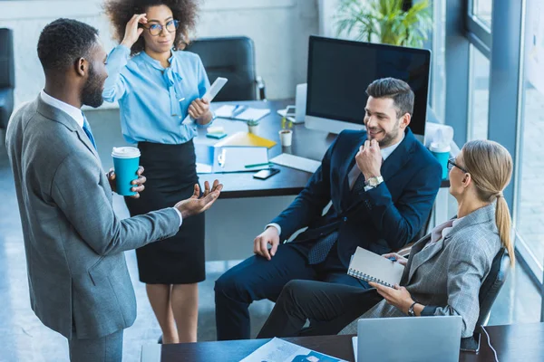 Heureux entrepreneurs multiculturels parlant au bureau — Photo de stock