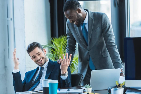 Homens de negócios multiculturais sorridentes falando no escritório — Fotografia de Stock