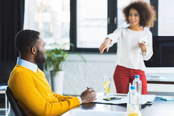 Femme d'affaires afro-américaine pointant du doigt un collègue en fonction — Photo de stock