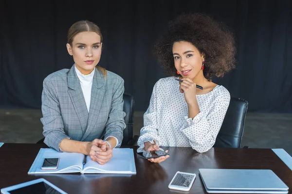 Multicultural businesswomen looking at camera in office — Stock Photo