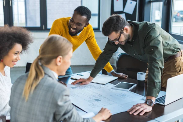 Heureux entrepreneurs multiculturels avec un plan directeur dans le bureau — Photo de stock