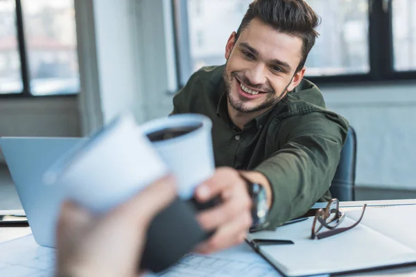 Cropped image of colleagues clinking cups of coffee in office — Stock Photo