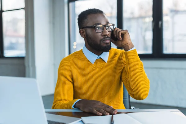 Homme d'affaires afro-américain parlant par smartphone au bureau — Photo de stock