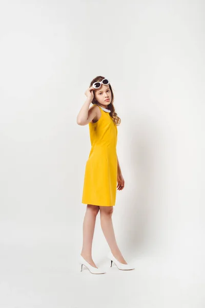 Beautiful teenage child in yellow dress on white — Stock Photo