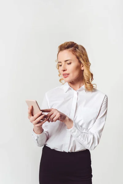 Elegante donna d'affari adulta utilizzando smartphone su bianco — Foto stock