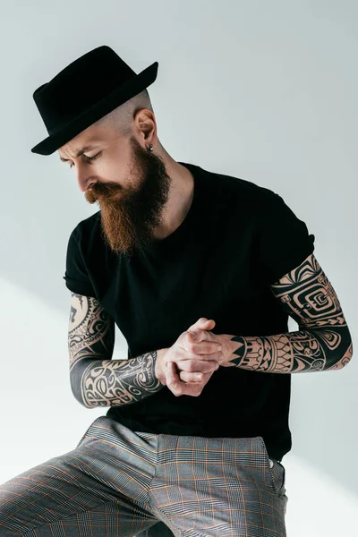 Bel homme tatoué barbu avec chapeau sur blanc — Photo de stock