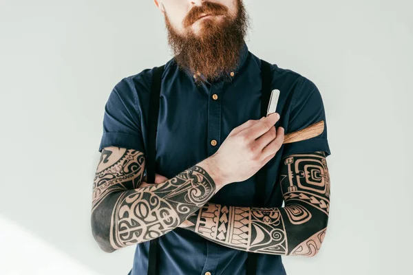 Cropped image of tattooed man holding razor — Stock Photo