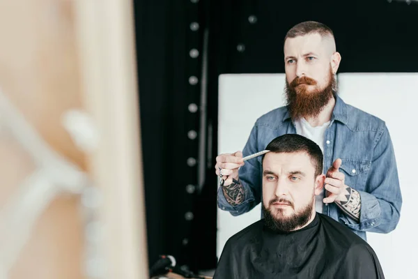 Barbiere guardando taglio di capelli cliente nello specchio al barbiere — Foto stock