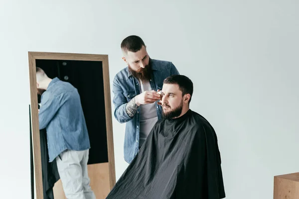 Barber shaving client hair at barbershop isolated on white — Stock Photo