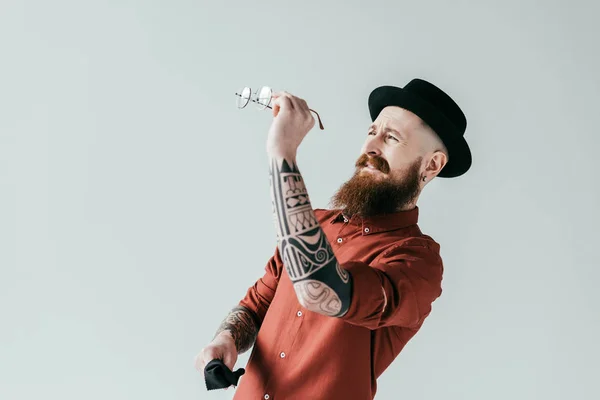 Bearded handsome man looking at glasses isolated on white — Stock Photo