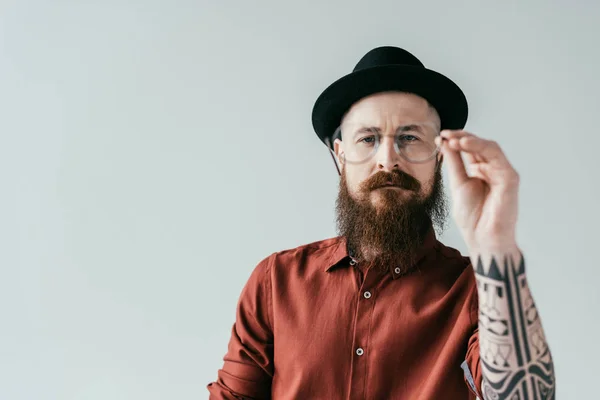 Бородатий красивий чоловік тримає окуляри ізольовані на білому — стокове фото