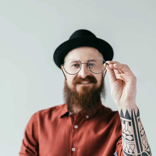 Sorridente barbuto bell'uomo che tiene gli occhiali isolati su bianco — Foto stock