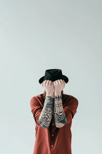 Homme tatoué couvrant le visage avec les mains isolées sur blanc — Stock Photo