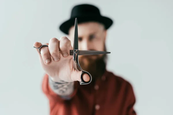 Handsome barber showing scissors isolated on white — Stock Photo