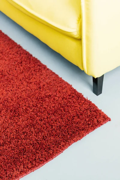 Teilansicht auf pelzigen Teppich und gelbe Ledercouch — Stockfoto