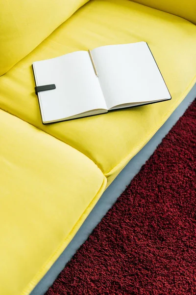 Empty textbook pages with pencil on yellow couch — Stock Photo