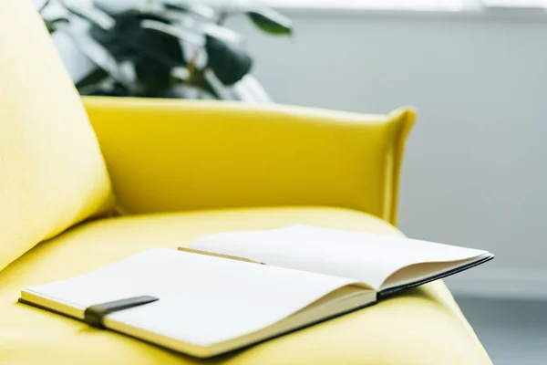 Empty textbook pages with pencil on yellow leather couch — Stock Photo