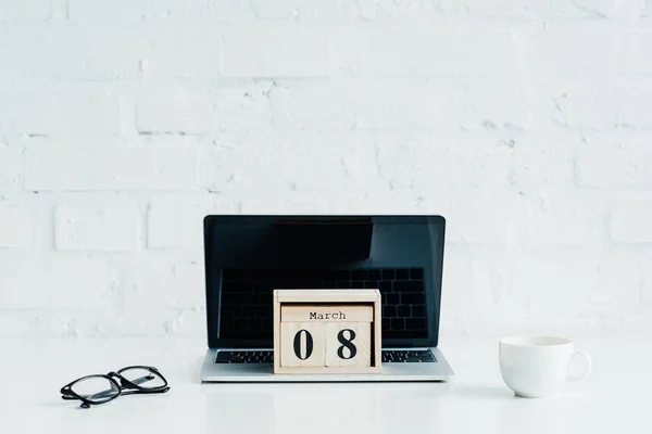 Calendário de madeira com data de 8 de março no laptop, conceito de dia internacional das mulheres — Fotografia de Stock