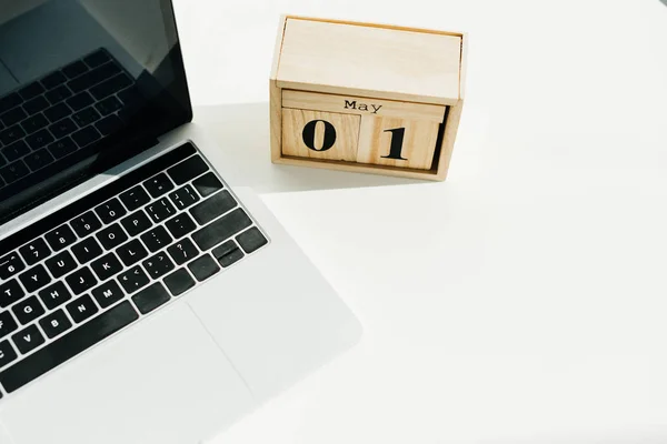 Vue du dessus du calendrier et de l'ordinateur portable en bois sur la surface blanche — Photo de stock