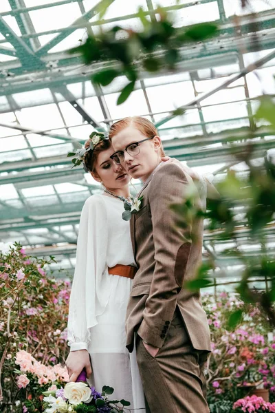 Portrait of stylish bride and groom in greenhouse — Stock Photo