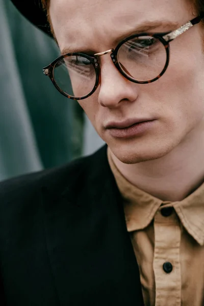 Портрет модного молодого чоловіка в окулярах дивиться на камеру — стокове фото