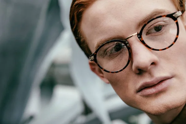 Headshot of stylish man with red hair in eyeglasses looking away — Stock Photo