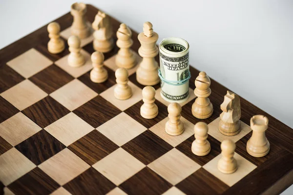 Chess board with cash and white chess pieces on white surface — Stock Photo