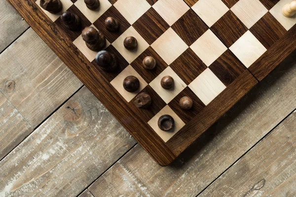 Image recadrée d'un échiquier avec des pièces d'échecs sur une surface en bois — Photo de stock