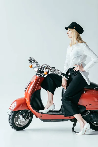 Stylish pretty woman posing by red retro scooter — Stock Photo