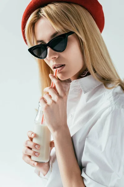 Fille blonde à la mode buvant du lait isolé sur blanc — Photo de stock