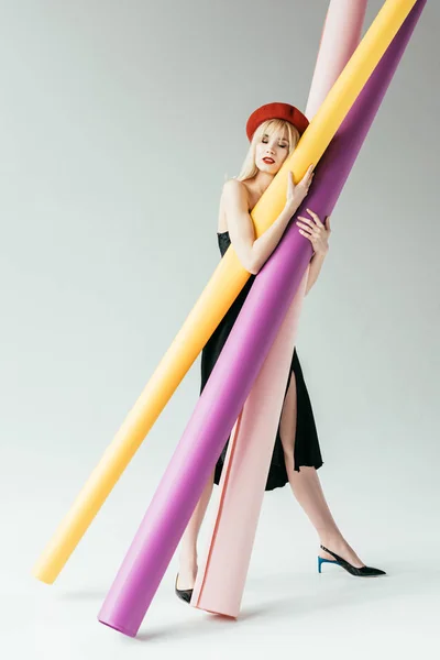 Menina loira elegante segurando rolos de papel coloridos — Fotografia de Stock
