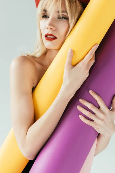 Elegante mujer bonita sosteniendo rollos de papel de colores aislados en gris - foto de stock