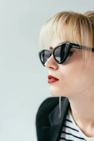 Elegante chica rubia en gafas de sol con labios rojos aislados en gris — Stock Photo