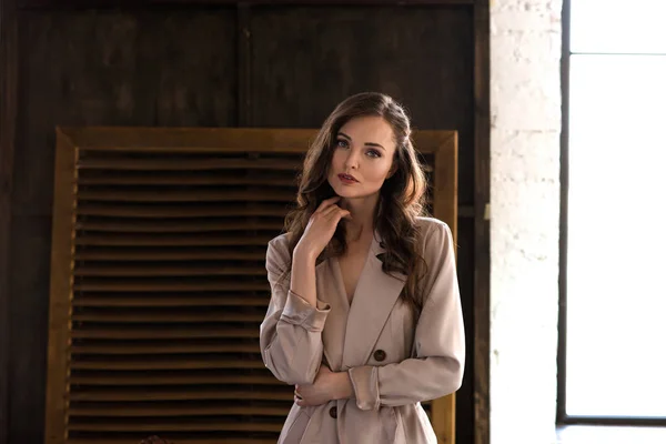 Elegant woman in classic beige trench coat — Stock Photo