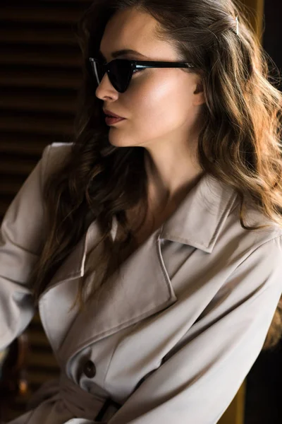 Elegante mujer de moda en gafas de sol y gabardina - foto de stock