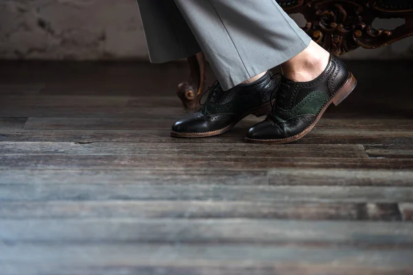 Low section of woman in stylish leather shoes and grey trousers — Stock Photo