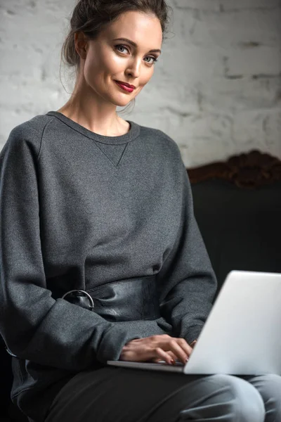 Belle femme souriante utilisant un ordinateur portable à l'intérieur — Photo de stock