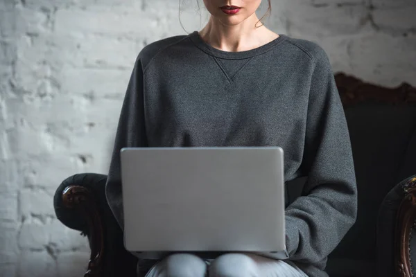 Recortado disparo de mujer joven en suéter gris utilizando el ordenador portátil - foto de stock