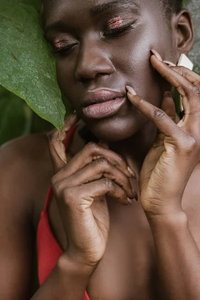 Retrato de tierna chica afroamericana posando con maquillaje brillo - foto de stock