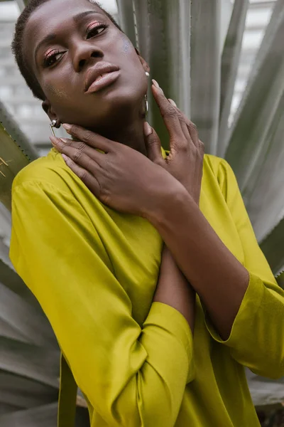 Elegante bella donna africana americana con glitter trucco posa in abito giallo — Foto stock