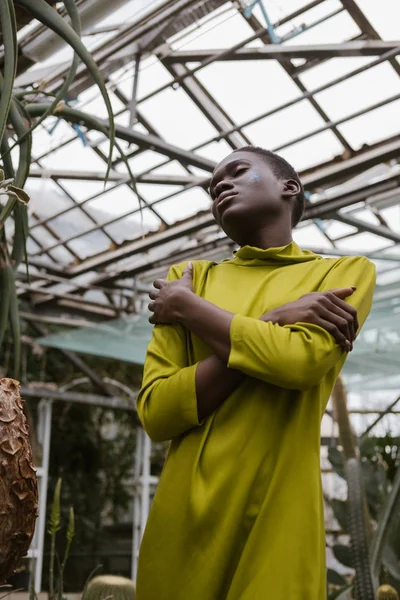 Fashionable sensual african american girl posing in greenhouse — Stock Photo