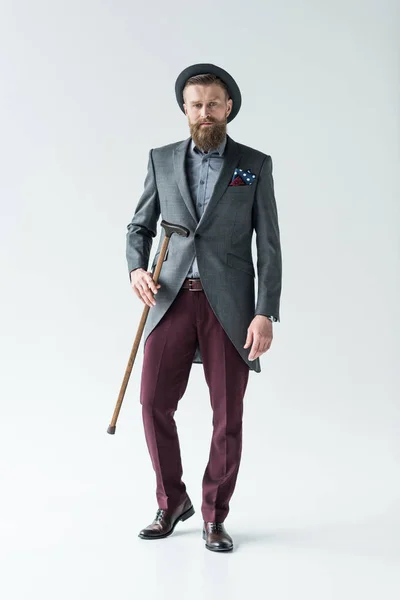 Stylish bearded man holding cane on light background — Stock Photo