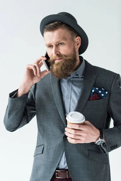 Bonito empresário em roupas de estilo vintage segurando copo de papel e falando no telefone isolado no fundo de luz — Fotografia de Stock