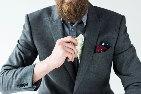 Vista recortada del hombre barbudo sacando dinero de su bolsillo aislado sobre fondo claro - foto de stock