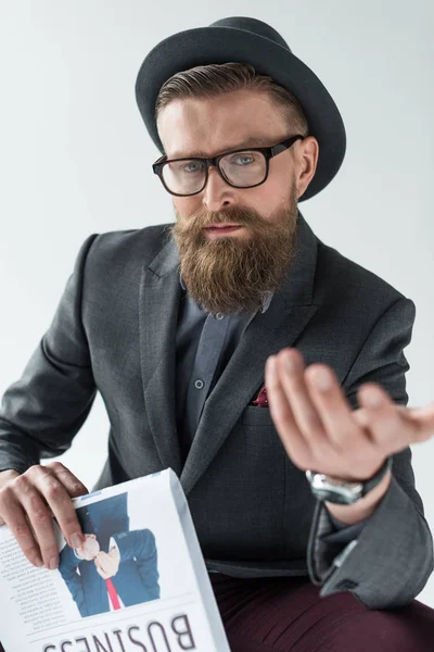 Stylish bearded businessman holding newspaper and gesturing isolated on light background — Stock Photo