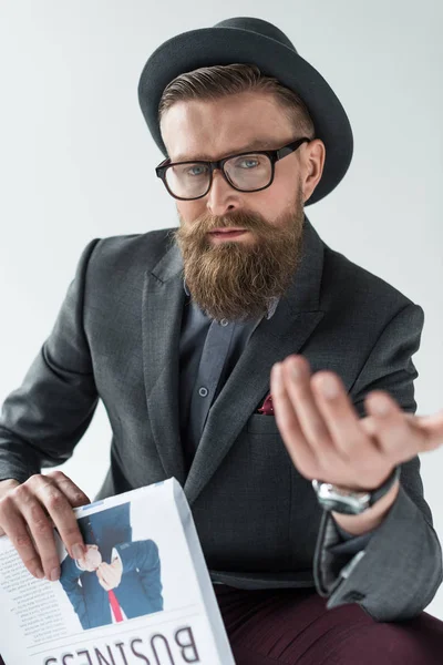 Stylischer bärtiger Geschäftsmann hält Zeitung in der Hand und gestikuliert isoliert auf hellem Hintergrund — Stockfoto