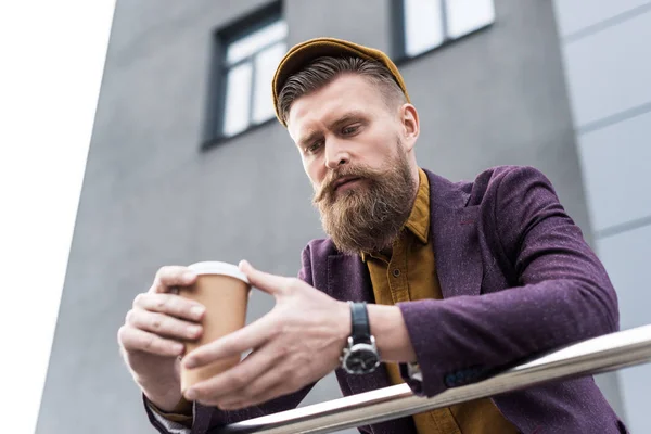 Empresário com bigode vintage e barba segurando xícara de café na rua — Fotografia de Stock