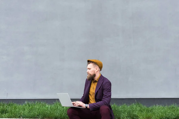 Bonito homem de negócios em roupas de estilo vintage trabalhando no laptop — Fotografia de Stock