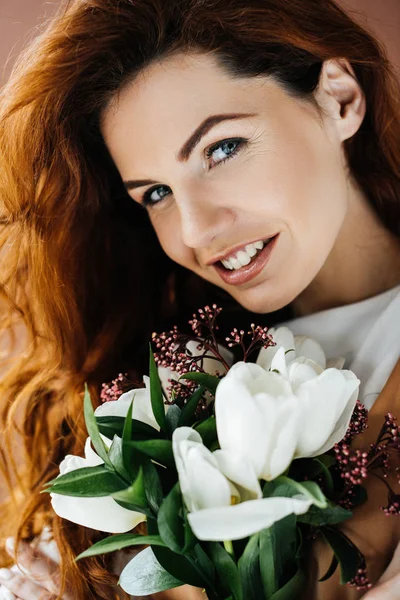 Belle jeune fille avec bouquet de fleurs isolées sur fond brun — Photo de stock